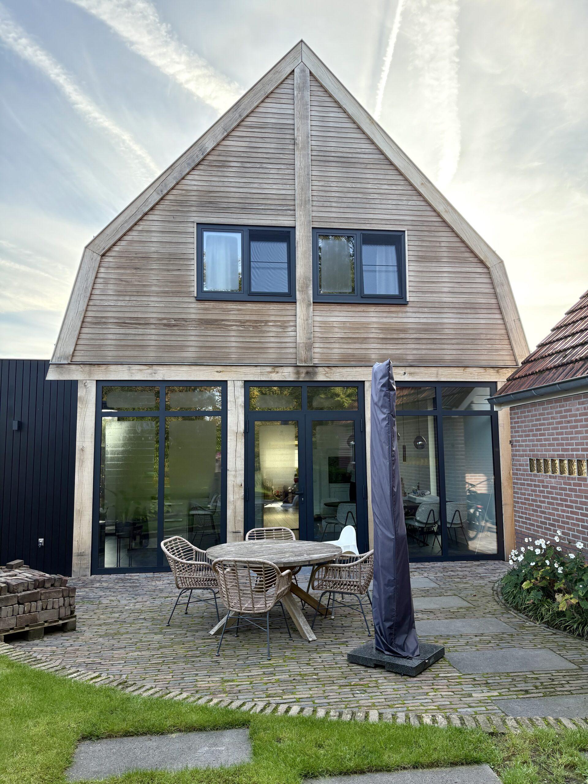 Achtergevel van een jaren 30-woning met eiken uitbreiding en aluminium kozijnen